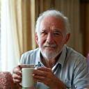 David, 55, looking peaceful and rested, enjoying a quiet morning with a cup of tea, showcasing improved sleep.